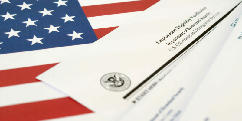 USCIS Form I-9 copy is lying on the American flag